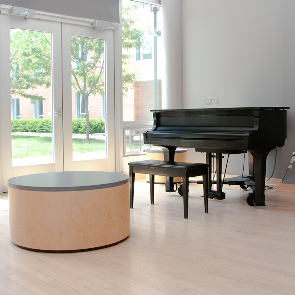 A piano and table in a room with a glass door
