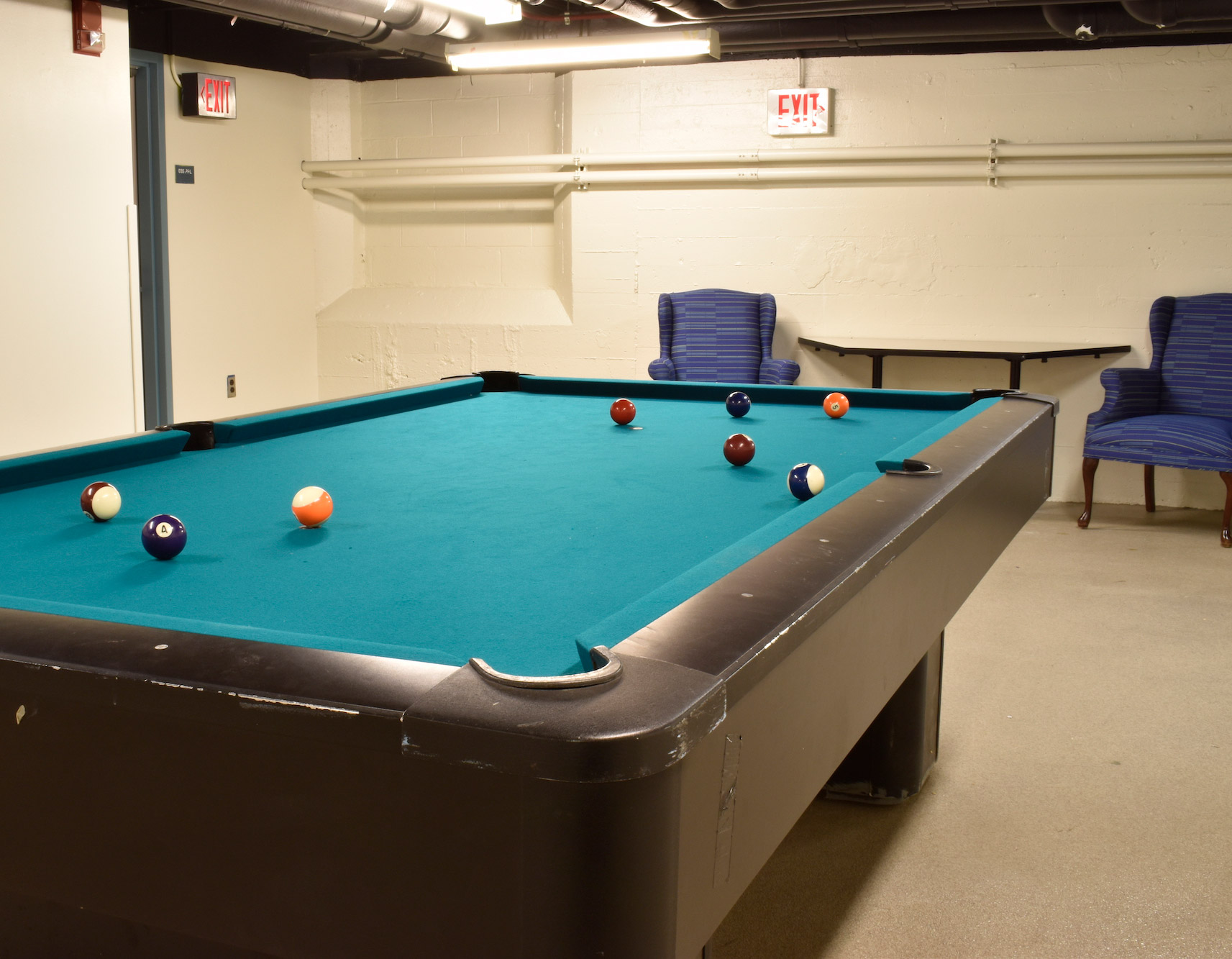 A pool table with seating in the background